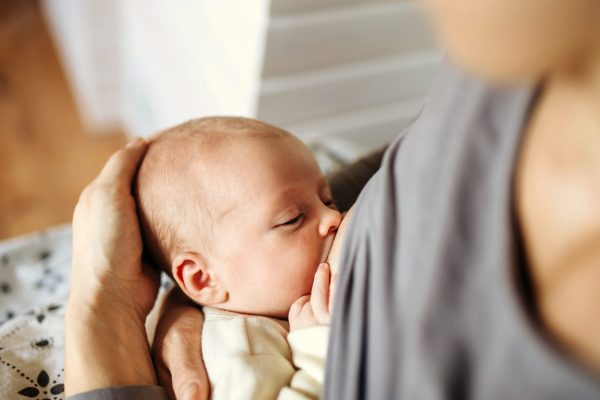 Close-up of mother brestfeeding her little newborn baby.